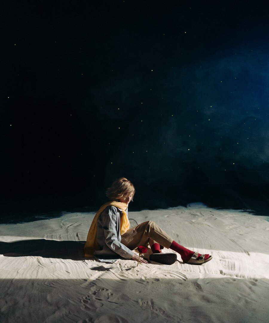 A young child looking up at a calm, star-filled evening sky