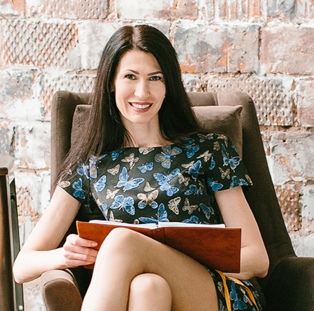 Olga, professional astrologer, seated with an open notebook during a reading